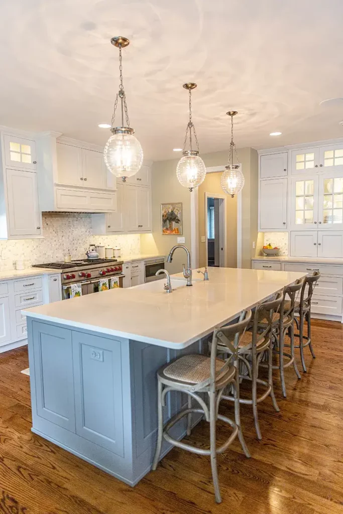 Custom kitchen cabinetry island with gray paint and counter height stools for added seating.