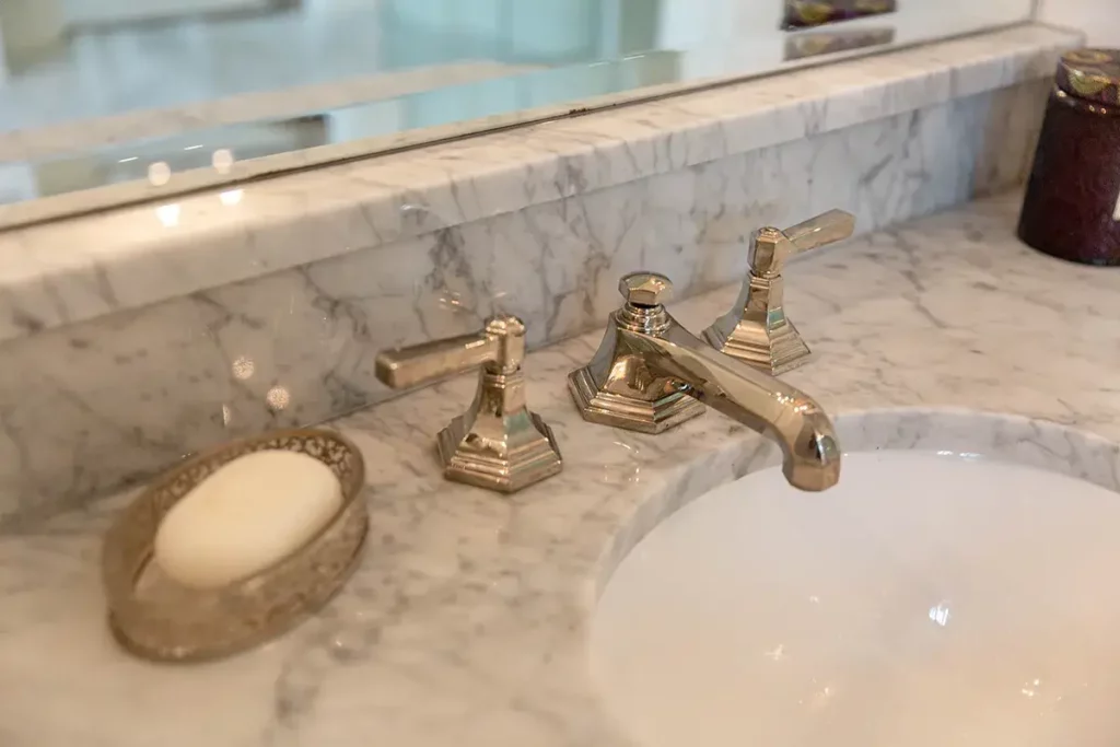 old fashion chrome finished classic sink faucet installed on a marble countertop