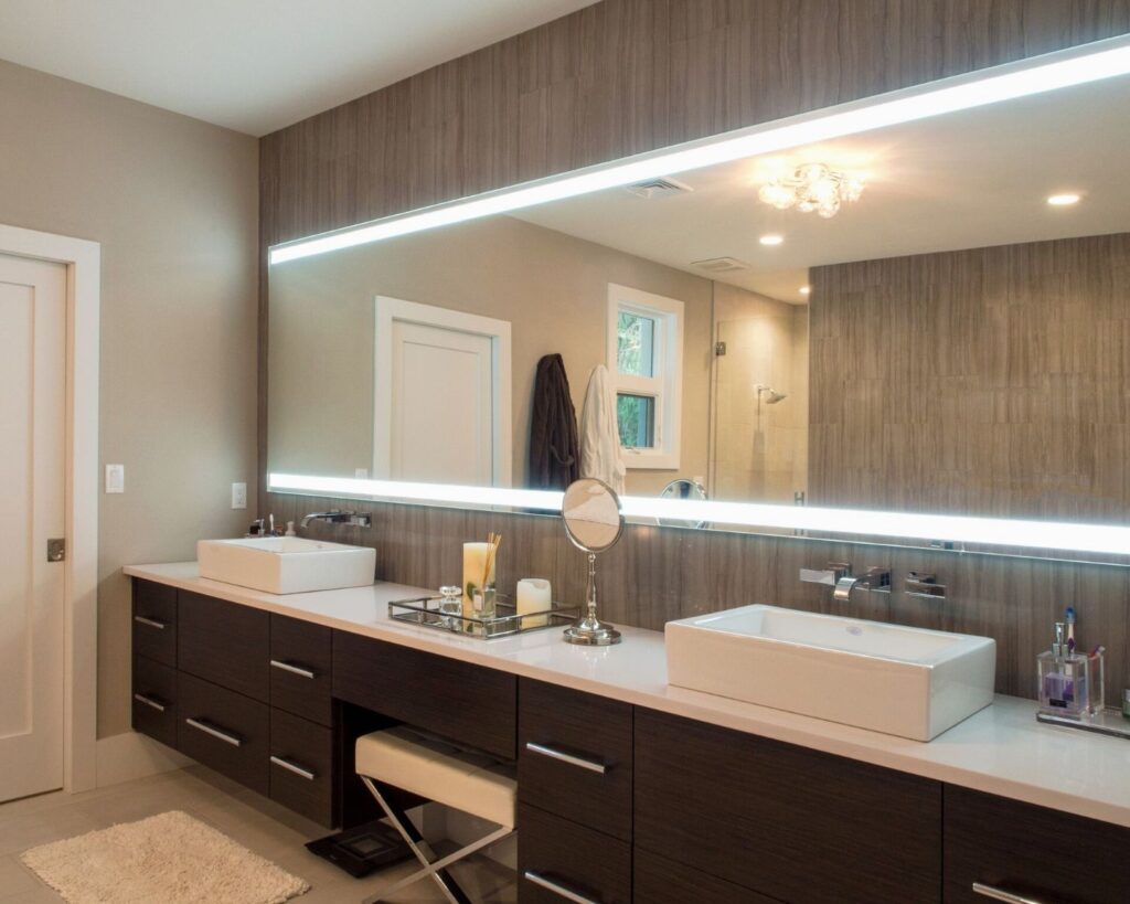 Dark floating double bathroom vanity with white countertop and large mirror with lighting.