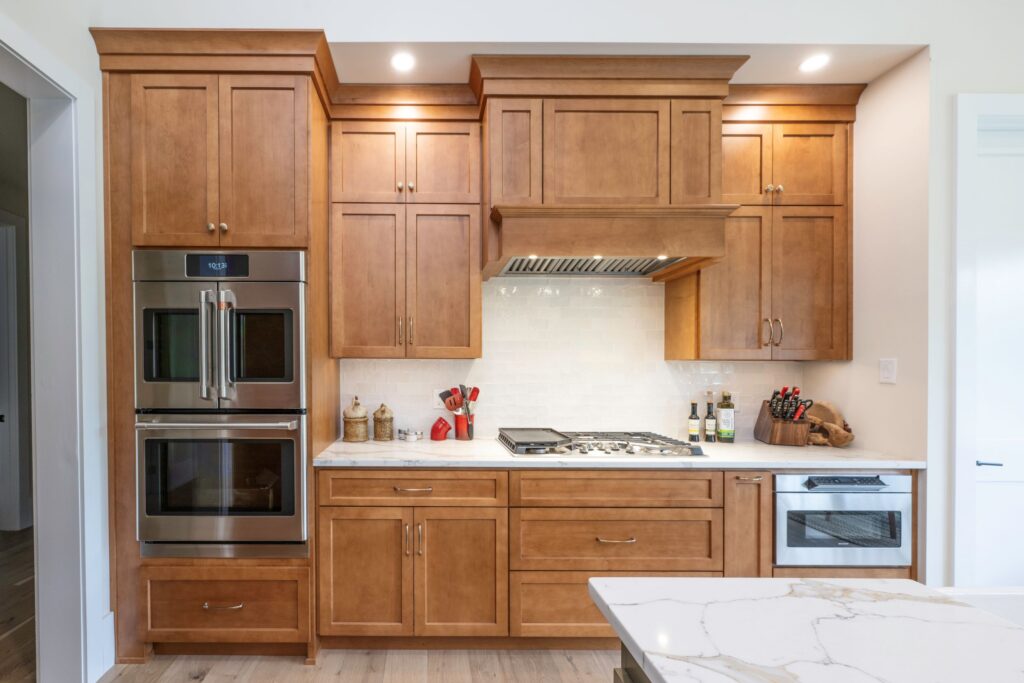 A wide view of the completed kitchen remodeling project in Bethlehem, PA, featuring hard maple cooking wall cabinetry and built-in stainless steel appliances.