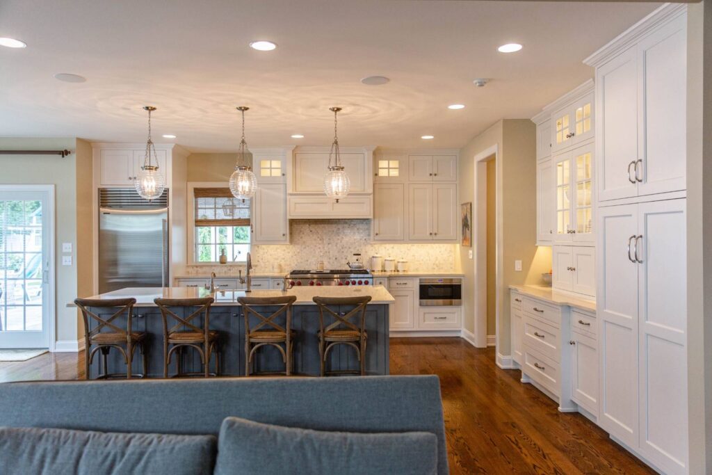 White custom kitchen in Allentown with tall cabinetry, a contrasting stained wood island, and cabinetry proportioned to the scale of the room.