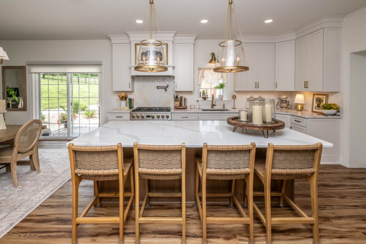White kitchen in Hellertown, PA with a large natural wood island, seating for four, and pendant lighting.